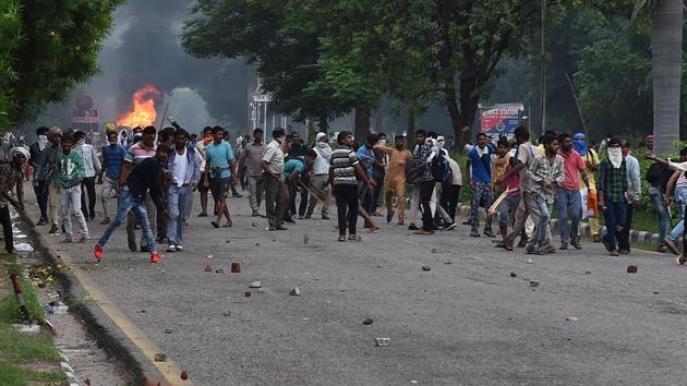 Followers of Gurmeet Ram Rahim Singh throw stones at security forces during clashes after the dera chief guru was convicted of rape in Panchkula . (AFP)