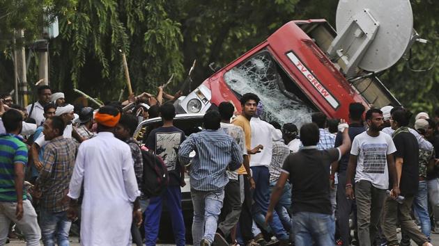 Dera Sacha Sauda supporters overturn an OB van on the streets of Panchkula.(AP Photo)