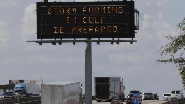 Motorists in Houston pass a sign warning of Hurricane Harvey as the storm intensifies in the Gulf of Mexico. Harvey is forecast to be a major hurricane when it makes landfall along the middle Texas coastline Friday. (David J. Phillip / AP)