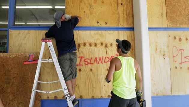 Scott Martin places a sheet of plywood as he helps board up windows in preparation for Hurricane Harvey in Corpus Christi, Texas. Two counties have ordered mandatory evacuations as Hurricane Harvey gathers strength as it drifts toward the Texas Gulf Coast. The strength of the winds, and rain may be catastrophic as the hurricane is expected to stall over southeastern Texas for a couple of days. (Eric Gay / AP)