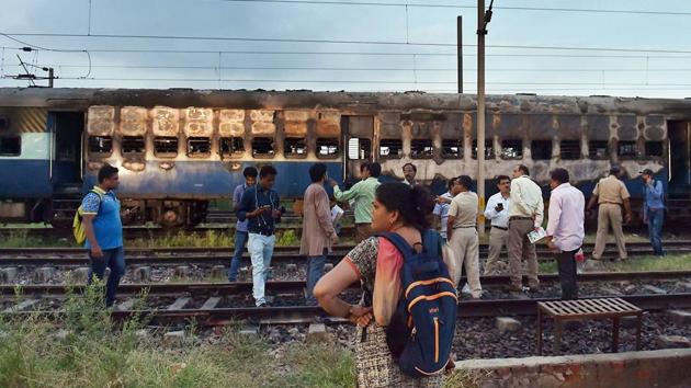 People stand near a vandalised train coach in Anand Vihar Sation in New Delhi on Friday, following Dera Sacha Sauda chief Gurmeet Ram Rahim’s conviction. (PTI Photo) People stand near a vandalised train coach in Anand Vihar Sation in New Delhi on Friday, following Dera Sacha Sauda chief Gurmeet Ram Rahim’s conviction. (PTI Photo)