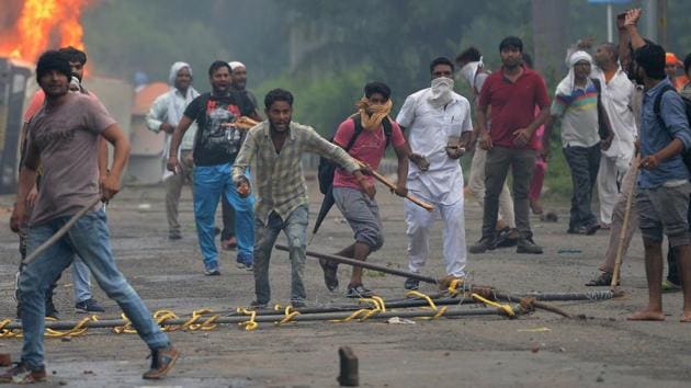 Supporters of Gurmeet Ram Rahim Singh clash with security forces next to burning vehicles in Panchkula on August 25, 2017. (AFP) Supporters of Gurmeet Ram Rahim Singh clash with security forces next to burning vehicles in Panchkula on August 25, 2017. (AFP)