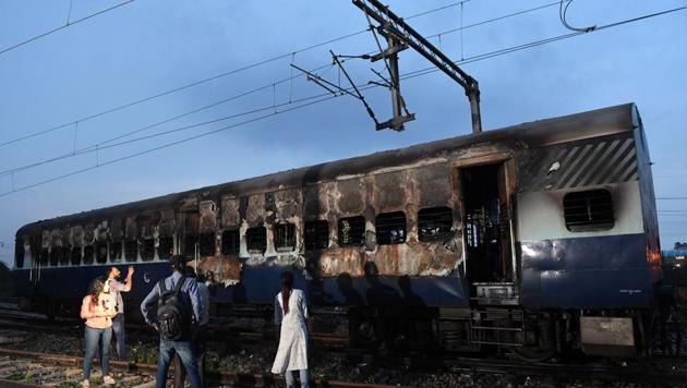 People stand next to a burned out train coach that had been set alight by supporters of a controversial guru, who had earlier been convicted of rape, at Anand Vihar railway station in New Delhi on August 25, 2017. (AFP Photo) People stand next to a burned out train coach that had been set alight by supporters of a controversial guru, who had earlier been convicted of rape, at Anand Vihar railway station in New Delhi on August 25, 2017. (AFP Photo)