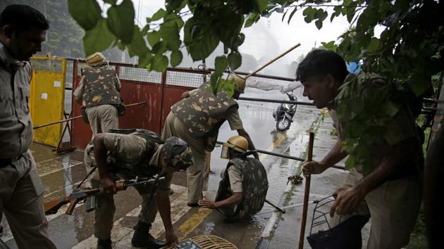 Indian policemen retreat after being attacked by Dera Sacha Sauda sect members in Panchkula. More than 15,000 paramilitary troops and police officers, some on horseback, were deployed in the town of Panchkula but found themselves overwhelmed by Dera supporters. (Altaf Qardri / AP)