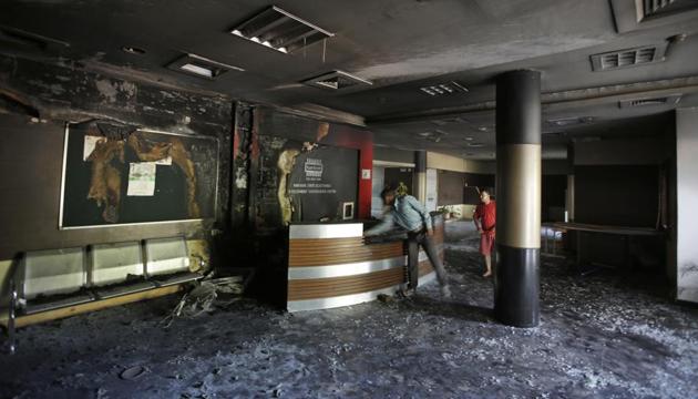 A man looks at the reception desk of a government building vandalized by Dera Sacha Sauda sect members a day before, in Panchkula. (AP Photo) A man looks at the reception desk of a government building vandalized by Dera Sacha Sauda sect members a day before, in Panchkula. (AP Photo)