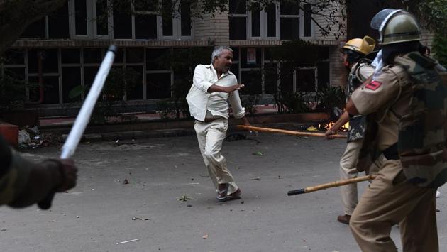 With the Dera chief flown away from the premises to a Rohtak jail, angry mobs began damaging public property, setting fire to vehicles and pelting stones on security personnel who tried to disperse crowds. (Money Sharma / AFP)