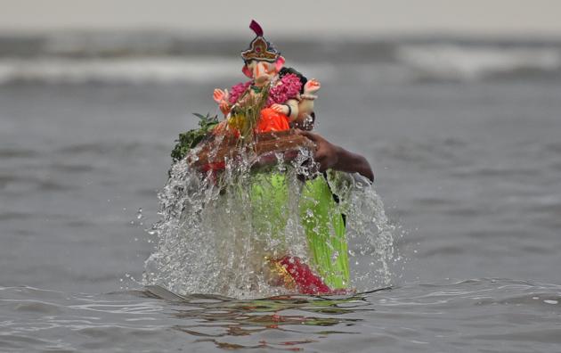 A devotee immerses a Ganpati idol at Mahim on Saturday. (Satyabrata Tripathy/HT Photo) A devotee immerses a Ganpati idol at Mahim on Saturday. (Satyabrata Tripathy/HT Photo)