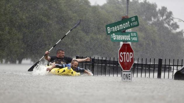 Two kayakers try to beat the current pushing them down an overflowing Brays Bayou along S Braeswood in Houston, Texas on Sunday (AP) Two kayakers try to beat the current pushing them down an overflowing Brays Bayou along S Braeswood in Houston, Texas on Sunday (AP)