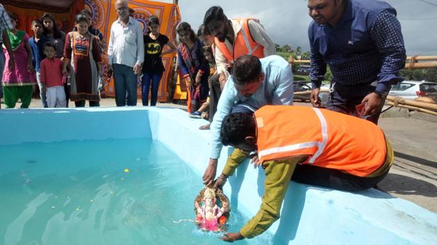 Devotees immersing an idol of Lord Ganesh in a tank in Pune on Saturday. (ht photo)