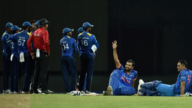 Rohit Sharma and MS Dhoni sit on the ground as game is stopped due to crowd disturbances at Pallekele. (PTI) 