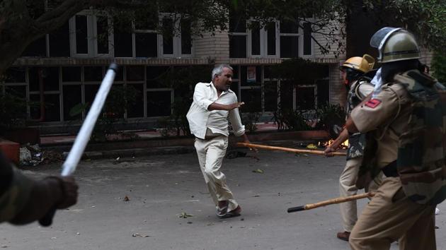A follower of Indian religious leader Gurmeet Ram Rahim Singh is hit with a stick during clashes between the controversial guru's followers and security forces in Panchkula on August,25. (Money Sharma/ AFP) A follower of Indian religious leader Gurmeet Ram Rahim Singh is hit with a stick during clashes between the controversial guru's followers and security forces in Panchkula on August,25. (Money Sharma/ AFP)