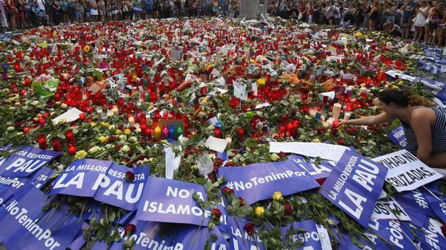 People place placards and candles to pay tribute to the victims of the Barcelona and Cambrils attacks on the Rambla boulevard in Barcelona on August 26, during a march against terrorism.Tens of thousands of Spaniards and foreigners staged a defiant march against terror through Barcelona on August 26 following last week's deadly vehicle rampages. (LLuis Gene/ AFP) People place placards and candles to pay tribute to the victims of the Barcelona and Cambrils attacks on the Rambla boulevard in Barcelona on August 26, during a march against terrorism.Tens of thousands of Spaniards and foreigners staged a defiant march against terror through Barcelona on August 26 following last week's deadly vehicle rampages. (LLuis Gene/ AFP)