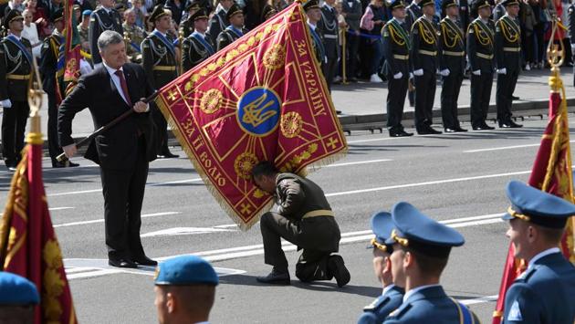 A unit commander pays honor to a flag hold by Ukrainian President Petro Poroshenko (L) during a military parade in Kiev on August 24, 2017 to celebrate the Independence Day. (Genya Savilov/ AFP) A unit commander pays honor to a flag hold by Ukrainian President Petro Poroshenko (L) during a military parade in Kiev on August 24, 2017 to celebrate the Independence Day. (Genya Savilov/ AFP)