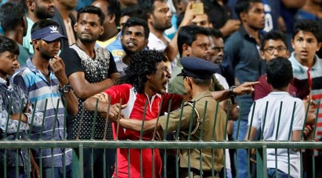 An angry Sri Lankan fan shouts at Sri Lankan players as a police officer tries to stop him during the third ODI against Sri Lanka.(REUTERS)