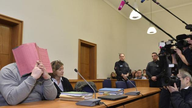 File photo from February 2015 shows former nurse Niels Hoegel, accused of multiple murders and attempted murders of patients, covering his face with a file at the district court in Oldenburg, Germany. Hoegel was convicted in 2015 of two murders and two attempted murders.(AP)