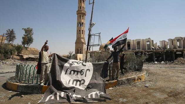 Fighters from the Hashed al-Shaabi (Popular Mobilisation units), backing the Iraqi forces, pose for a photograph with a flag of the Islamic State in Tal Afar's Qalea central district during an operation to retake the city on August 27, 2017. Iraqi forces backed by local militia and a US-led coalition were poised to drive the IS from Tal Afar, dealing another blow to the jihadis. (AFP) Fighters from the Hashed al-Shaabi (Popular Mobilisation units), backing the Iraqi forces, pose for a photograph with a flag of the Islamic State in Tal Afar's Qalea central district during an operation to retake the city on August 27, 2017. Iraqi forces backed by local militia and a US-led coalition were poised to drive the IS from Tal Afar, dealing another blow to the jihadis. (AFP)