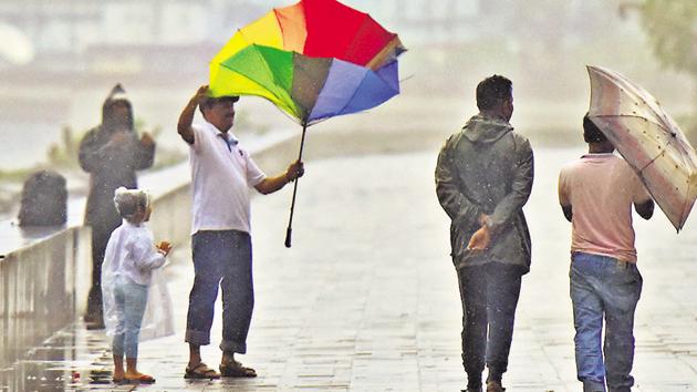 A man does a balancing act with his umbrella in Mumbai on Monday.(Satyabrata Tripathy/HT Photo)