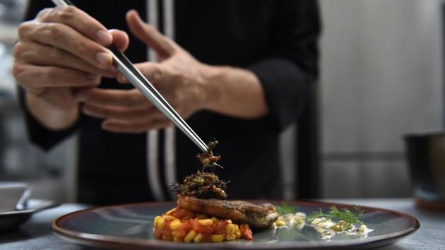Edible winged ants being placed on a fish fillet inside the kitchen of Insects in the Backyard, which says it offers the first insect-based fine-dining menu, in Bangkok. (AFP) Edible winged ants being placed on a fish fillet inside the kitchen of Insects in the Backyard, which says it offers the first insect-based fine-dining menu, in Bangkok. (AFP)