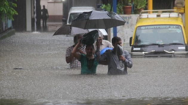 People walk through a flooded street at Hindamata in Mumbai on Tuesday. (Pratik Chorge/HT Photo) People walk through a flooded street at Hindamata in Mumbai on Tuesday. (Pratik Chorge/HT Photo)
