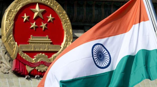 Indian national flag is flown next to the Chinese national emblem during a welcome ceremony for visiting Indian officials outside the Great Hall of the People in Beijing.(AP)