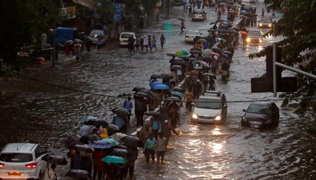 Commuters walk through water-logged roads after rains in Mumbai on August 29, 2017.(REUTERS) Commuters walk through water-logged roads after rains in Mumbai on August 29, 2017.(REUTERS)