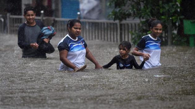 People wade through waist-deep water on a flooded Mumbai street. (PTI photo) People wade through waist-deep water on a flooded Mumbai street. (PTI photo)