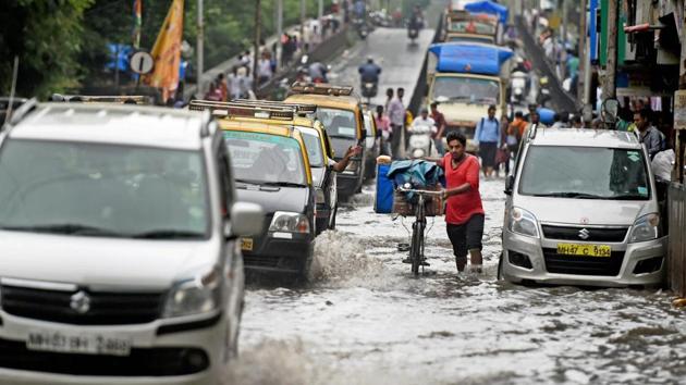 Vehicles ply on a waterlogged road after heavy rains left Mumbai submerged on Wednesday. (PTI Photo) Vehicles ply on a waterlogged road after heavy rains left Mumbai submerged on Wednesday. (PTI Photo)