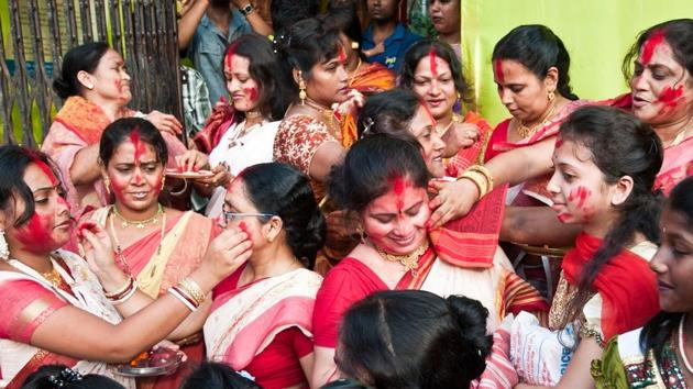 Married Bengali Hindu women smear and play with vermilion during Sindur Khela traditional ceremony on the final day of Durga Puja festival.(Shutterstock)