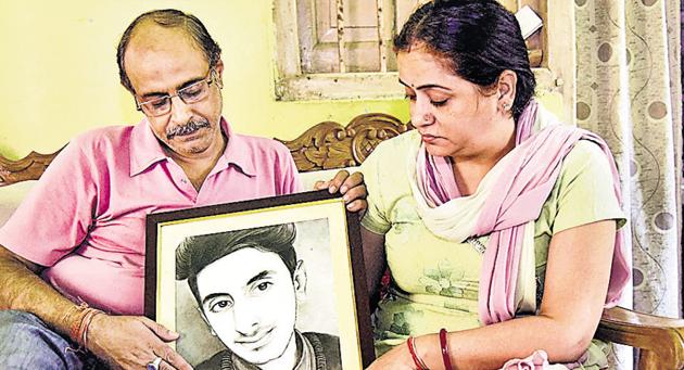 The parents of Aditya Sachdeva with a portrait of their son at their residence in Gaya.(PTI file photo)