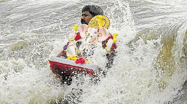 A devotee immerses a Ganpati idol at Dadar Chowpatty on Wednesday. (Kunal Patil/HT Photo) A devotee immerses a Ganpati idol at Dadar Chowpatty on Wednesday. (Kunal Patil/HT Photo)