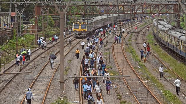 With few or no trains available, commuters walk on railway tracks at Kurla on Wednesday to get to their destination.(Satyabrata Tripathy/HT)