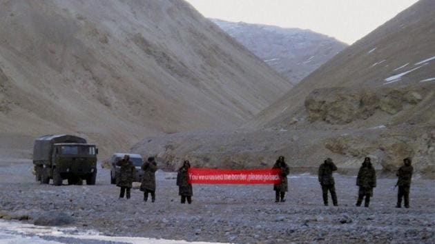 Chinese troops hold a banner which reads "You've crossed the border, please go back" in Ladakh, India (File Photo)(AP)