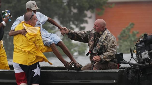 Rescuers help a man from the flooding of Hurricane Harvey on August 30, 2017 in Port Arthur, Texas.(AFP Photo) Rescuers help a man from the flooding of Hurricane Harvey on August 30, 2017 in Port Arthur, Texas.(AFP Photo)