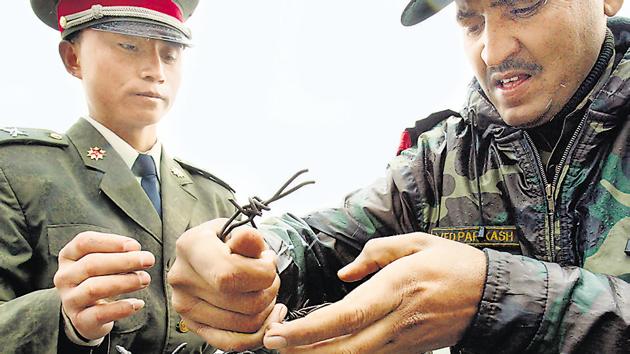 File photo from July 2006 shows a Chinese soldier (left) and an Indian soldier placing a barbed wire fence following a meeting of military representatives at Nathu La border crossing in India's northeastern Sikkim state.(AFP)