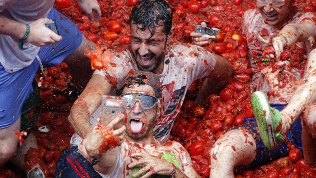 The annual ‘Tomatina’ battle, which has become major tourist attraction, about 160 tons of tomatoes are dumped by the trucks for around 20,000 participants in the town of Buñol. (Alberto Saiz / AP)