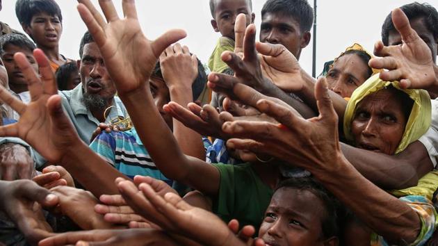 Rohingya refugees reach for food aid at Kutupalong refugee camp in Ukhiya near the Bangladesh-Myanmar border. The International Organization for Migration said August 30 that at least 18,500 Rohingya had crossed into Bangladesh since fighting erupted in Myanmar's neighbouring Rakhine state six days earlier. (AFP Photo) Rohingya refugees reach for food aid at Kutupalong refugee camp in Ukhiya near the Bangladesh-Myanmar border. The International Organization for Migration said August 30 that at least 18,500 Rohingya had crossed into Bangladesh since fighting erupted in Myanmar's neighbouring Rakhine state six days earlier. (AFP Photo)