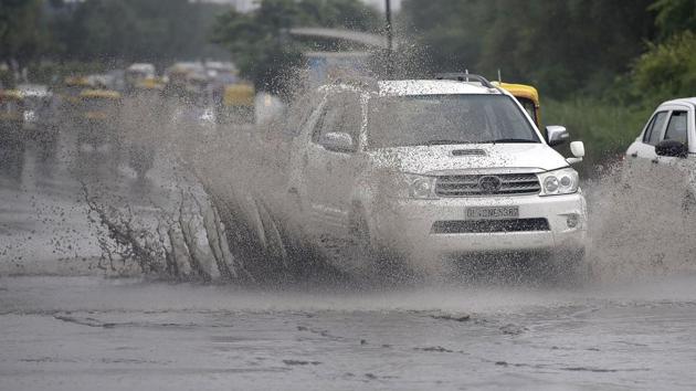 Vehicles wade through waterlogged roads in New Delhi on Thursday.(Raj K Raj/HT PHOTO)