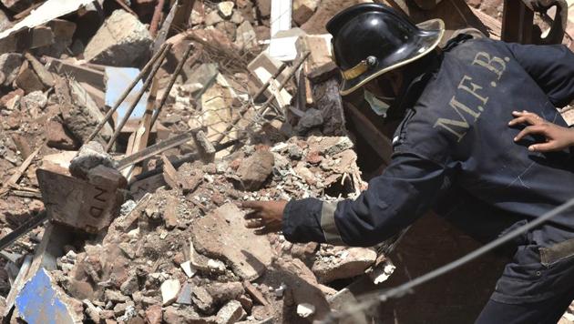 A emergency service worker looks at a hand sticking of the rubble of a collapsed building in Mumbai on Thursday. (Anshuman Poyrekar/HT Photo) A emergency service worker looks at a hand sticking of the rubble of a collapsed building in Mumbai on Thursday. (Anshuman Poyrekar/HT Photo)