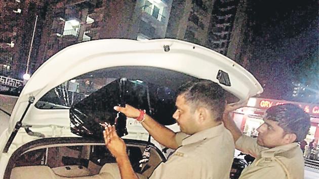 Cops removing black film from cars in Noida. Cops removing black film from cars in Noida.