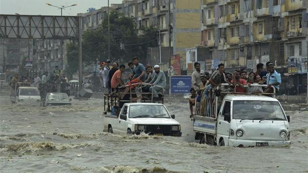 Pakistani commuters travel on a flooded street following heavy rainfall in the port city of Karachi on August 31, 2017. Monsoon rains in Karachi left at least 23 people dead in flood-related mishaps. The destruction came on the heel of downpours since Wednesday.(AP)