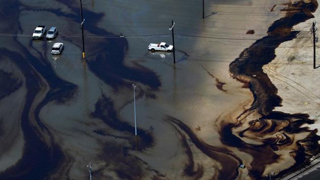 Vehicles sit amid leaked fuel mixed in with flood waters caused by Tropical Storm Harvey in the parking lot of Motiva Enterprises LLC in Port Arthur, Texas. Flooding from tropical storm Harvey shut nearly a fifth of US oil refining capacity with at least 3.6 million barrels per day of refining capacity offline in Texas and Louisiana, or nearly 20% of total US capacity as per company reports and Reuters estimates.  (Adrees Latif / REUTERS) 