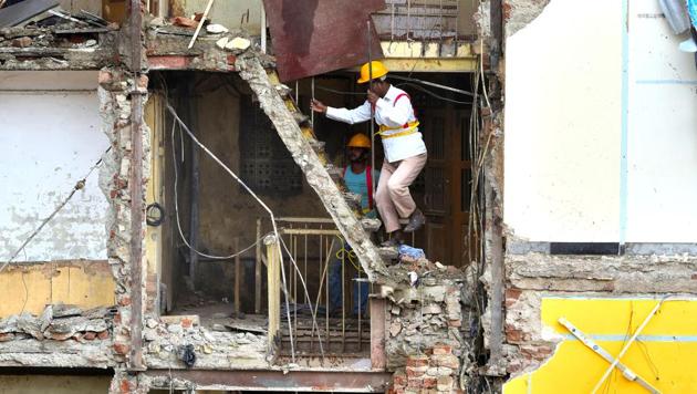 Rescue workers inspect the site of the collapse on Thursday.(Anshuman Poyrekar/HT)