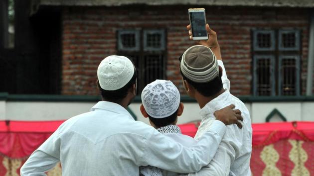 Men take a selfie at a mosque in Jammu. (Nitin Kanotra/HT)