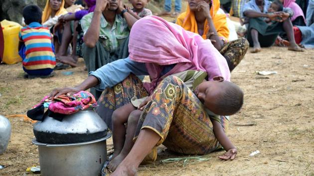 An elderly Rohingya refugee asleep with while holding her sleeping grandson in her lap at Kutupalong refugee camp in Ukhiya after crossing the border from Myanmar into Bangladesh. At least 6,000 Rohingya civilians fleeing renewed violence in Myanmar are stranded near the border with Bangladesh which is blocking their entry, a senior Bangladeshi official said August 29, as the United Nations urged Dhaka to let them in. (Emrul Kamal / AFP) An elderly Rohingya refugee asleep with while holding her sleeping grandson in her lap at Kutupalong refugee camp in Ukhiya after crossing the border from Myanmar into Bangladesh. At least 6,000 Rohingya civilians fleeing renewed violence in Myanmar are stranded near the border with Bangladesh which is blocking their entry, a senior Bangladeshi official said August 29, as the United Nations urged Dhaka to let them in. (Emrul Kamal / AFP)