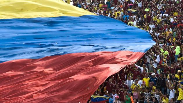 Venezuelan fans deploy a huge national flag during their 2018 World Cup qualifier football match against Colombia, in San Cristobal, Venezuela. (JUAN BARRETO / AFP) Venezuelan fans deploy a huge national flag during their 2018 World Cup qualifier football match against Colombia, in San Cristobal, Venezuela. (JUAN BARRETO / AFP)