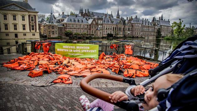 A baby in a stroller passes by life jackets displayed by International anti-poverty organisation OXFAM NOVIB in front of the Dutch Parliament at the Binnenhof in The Hague. The jackets serve as a visual reminder to the Dutch government of the suffering and risks hundreds of thousands of refugees have endured. (AFP) A baby in a stroller passes by life jackets displayed by International anti-poverty organisation OXFAM NOVIB in front of the Dutch Parliament at the Binnenhof in The Hague. The jackets serve as a visual reminder to the Dutch government of the suffering and risks hundreds of thousands of refugees have endured. (AFP)