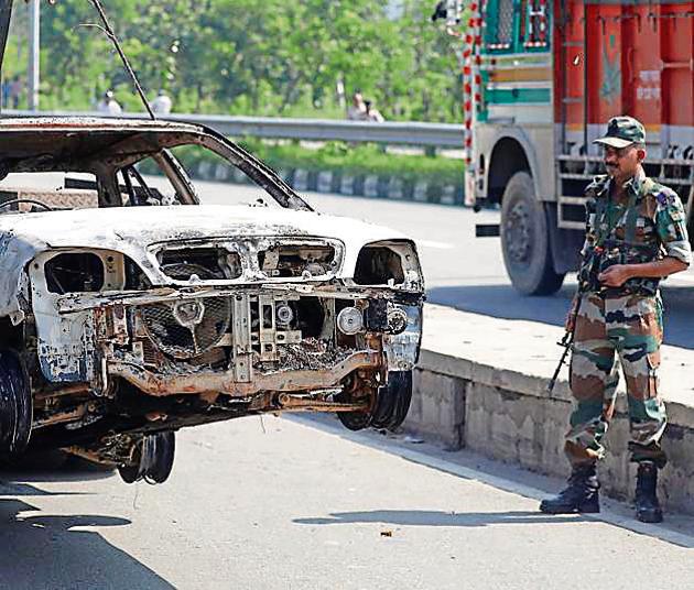 A soldier looks at a car damaged in arson, a day after the August 25 violence in Panchkula. (REUTERS) A soldier looks at a car damaged in arson, a day after the August 25 violence in Panchkula. (REUTERS)