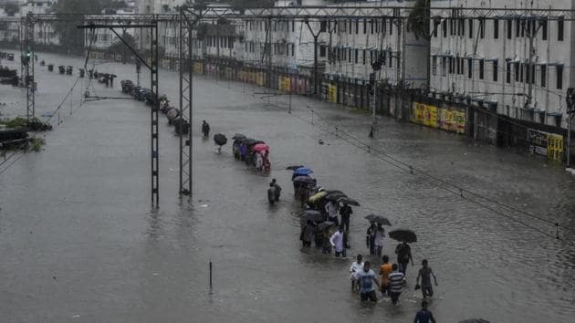 Commuters had to wade through submerged tracks on Tuesday.(HT)