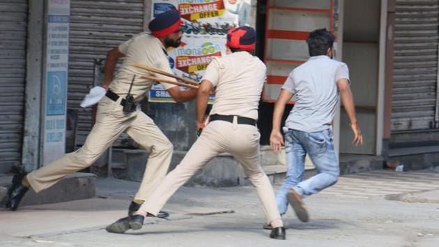 Punjab police cops apprehending a man in Dhobi Bazaar who was roaming in the market despite curfew been imposed in the city in view of sentencing of Dera Sacha Sauda head Gurmeet Ram Rahim. (Sanjeev KUmar / HT Photo) Punjab police cops apprehending a man in Dhobi Bazaar who was roaming in the market despite curfew been imposed in the city in view of sentencing of Dera Sacha Sauda head Gurmeet Ram Rahim. (Sanjeev KUmar / HT Photo)