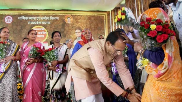 Madhya Pradesh chief minister Shivraj Singh Chouhan welcomes and seeks blessings of elderly pilgrims during a programme organised on the completion of five years of 'Mukhyamantri Teerth Darshan Yojana' in Bhopal on Sunday.(PTI Photo)